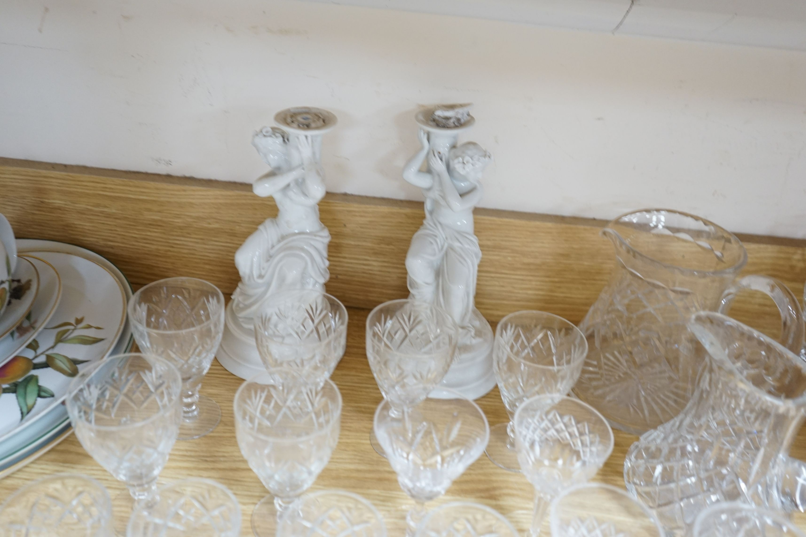 A suite of cut drinking glassware and a pair of porcelain figural lamp stems